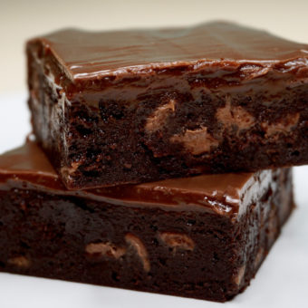 Two decadent chocolate coffee brownies topped with a Bailey's-infused chocolate ganache