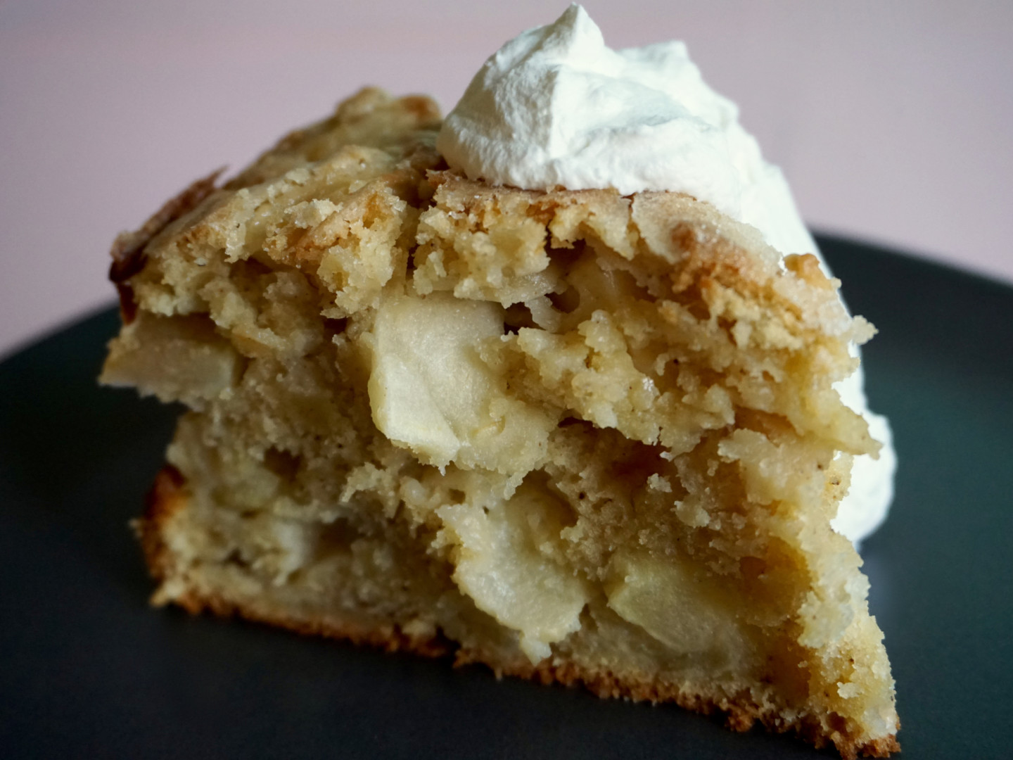 A slice of Irish apple cake topped with a dollop of whipped cream